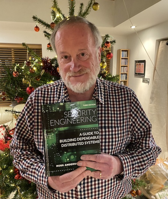 Ross Anderson, holding a coyp of the latest edition of Security Engineering.